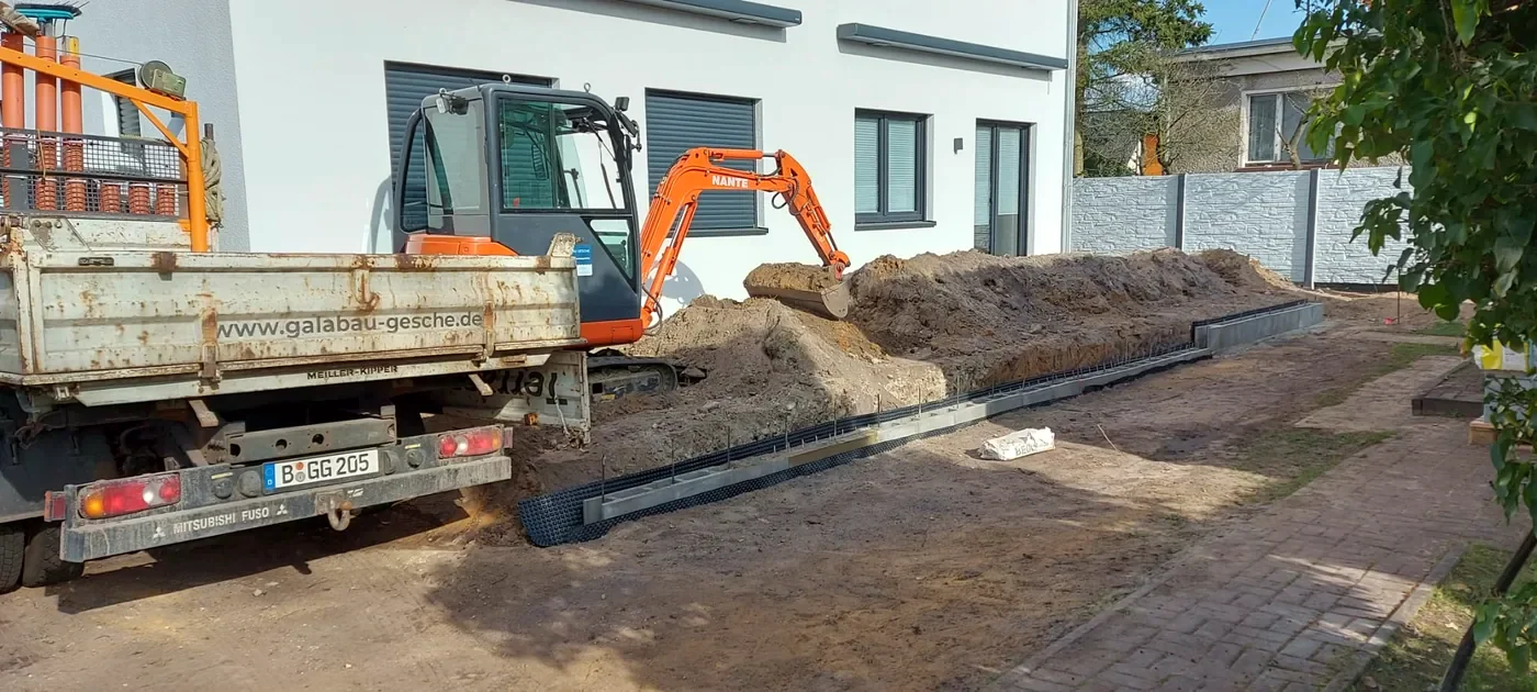 Minibagger und Materialanlieferung bei den Erdarbeiten am Doppelhaus