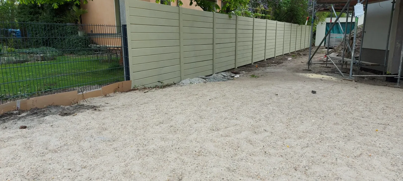Betonzaun in Holzoptik als Sicht- und Lärmschutz entlang einer Grundstücksgrenze