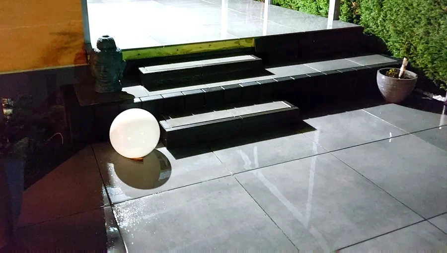 Terrasse aus Feinsteinzeugplatten mit dunklen Blockstufen