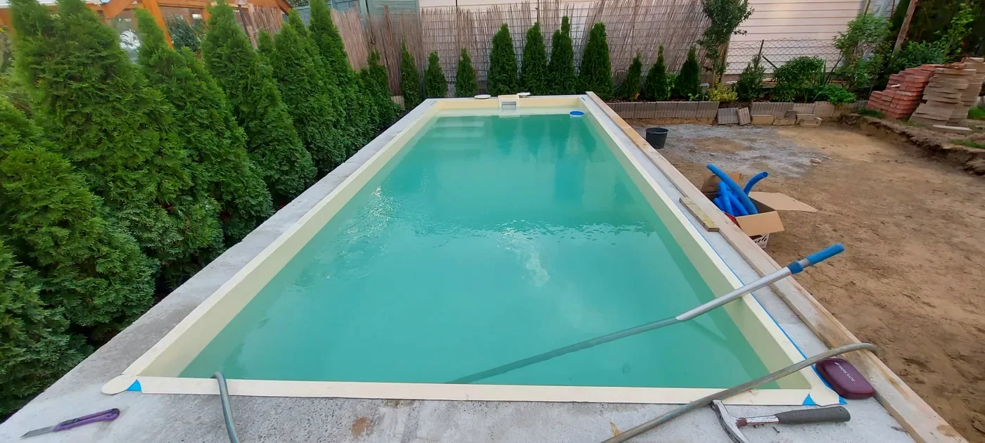 Mit Folie ausgekleidetes Poolbecken beim Befüllen mit Wasser
