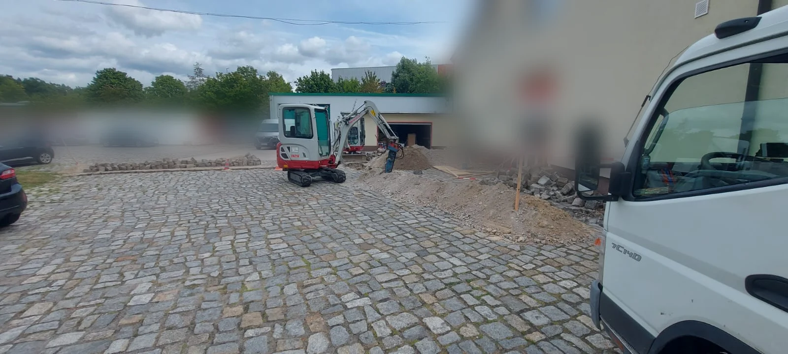 Baustelle für einen Leitungsgraben in einem gepflasterten Innenhof