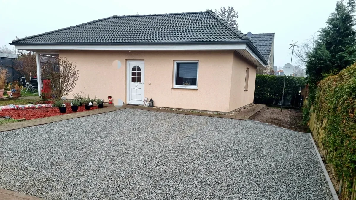 Stellplatz aus Granitsplitt in Kieswaben vor einem Bungalow
