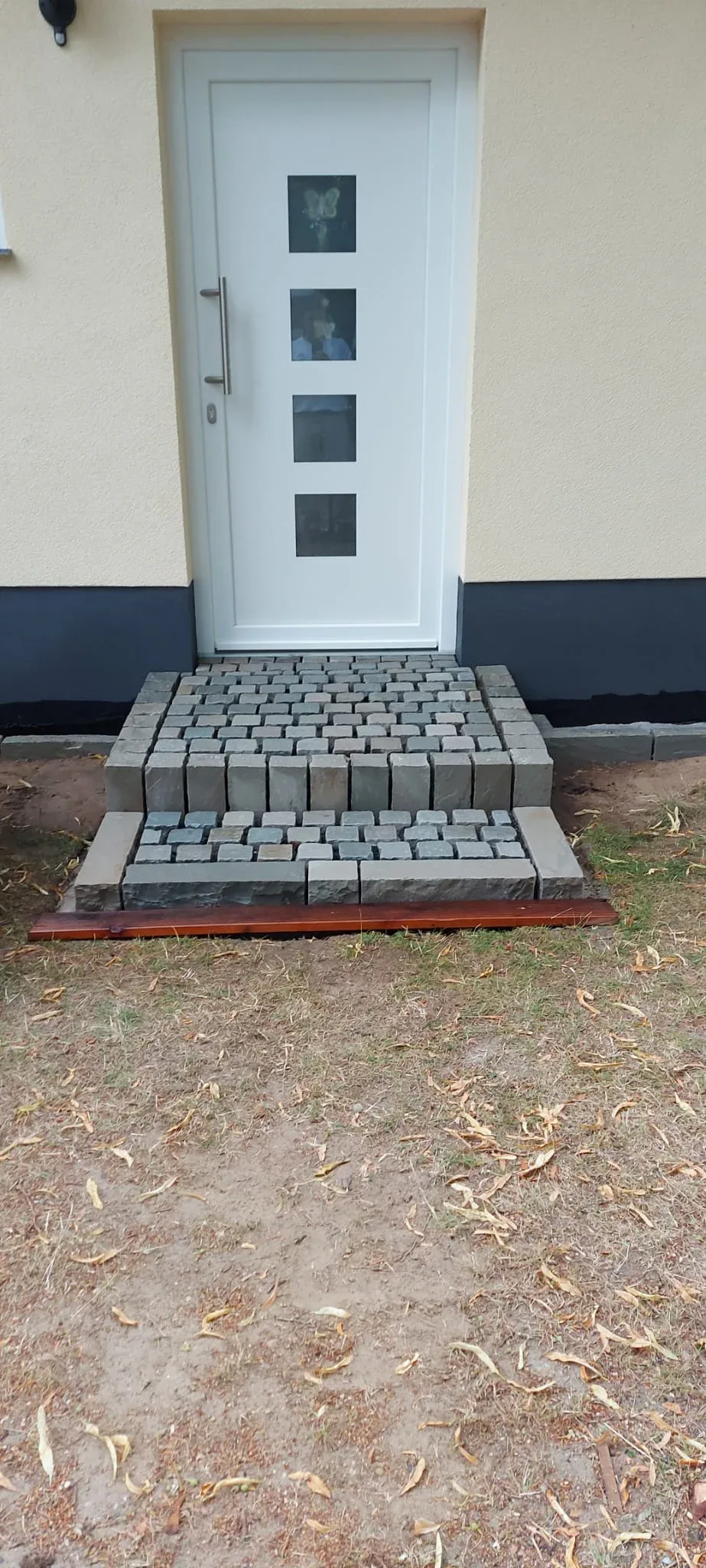 Podest und Stufe aus Kleinsteinpflaster in Sandstein vor einer Haustür