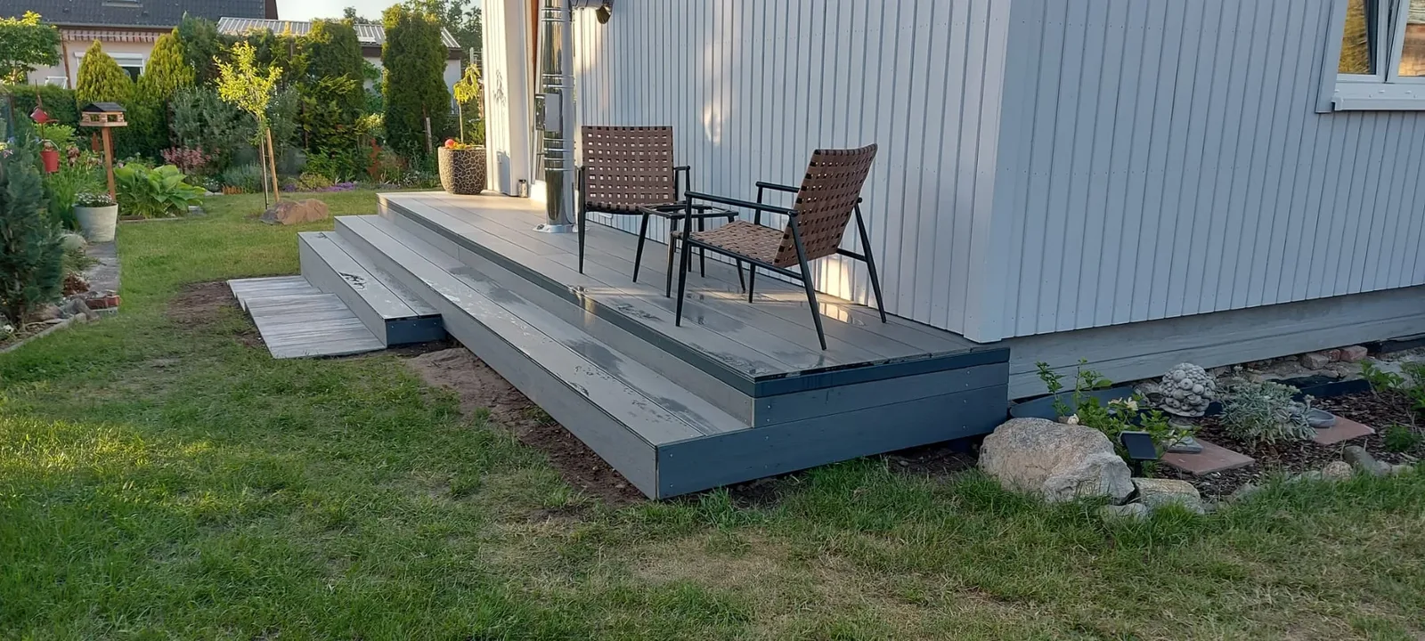 WPC-Terrasse mit Stufen auf einer Unterkonstruktion aus Stahl an einem Wohnhaus